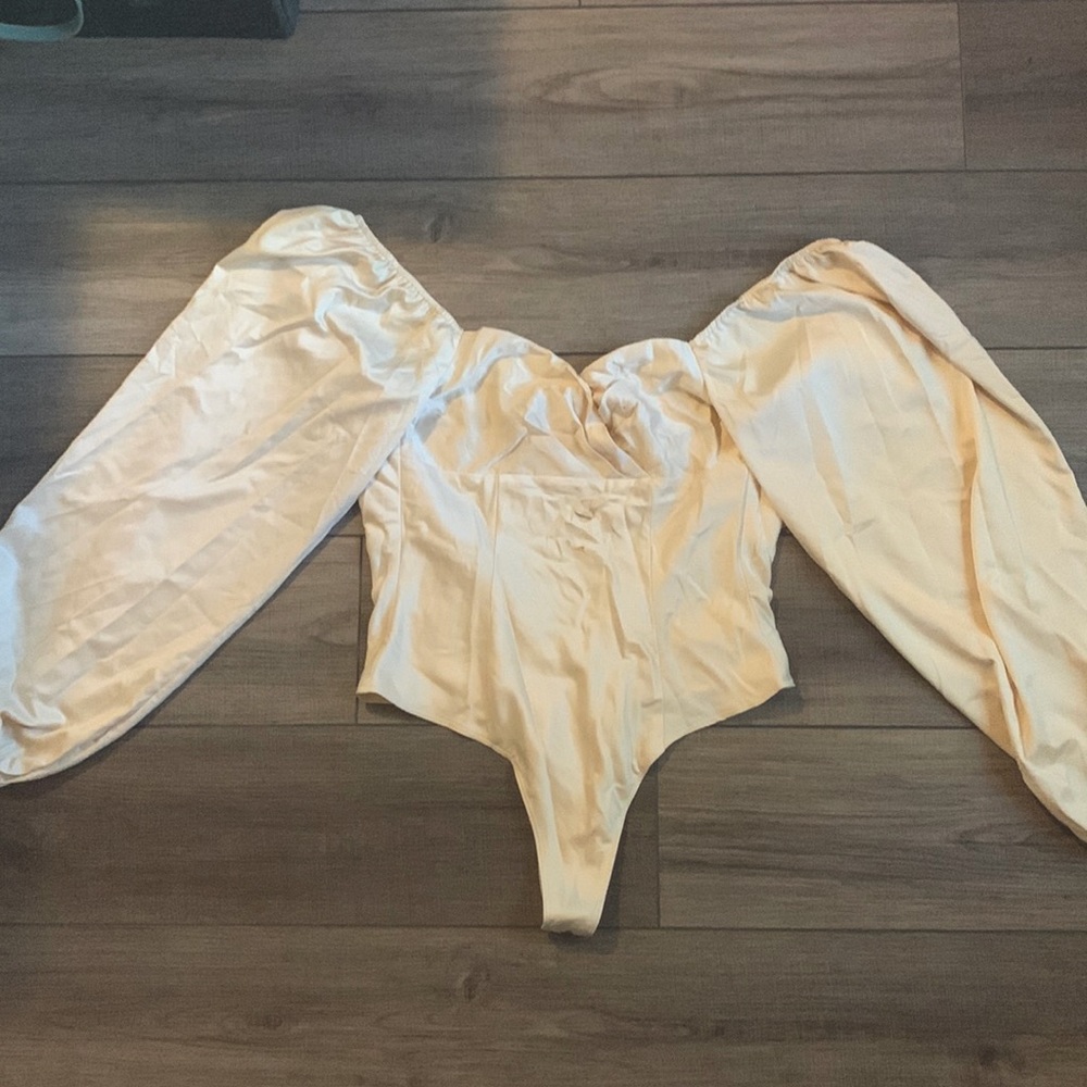A beautiful cream-colored satin corset bodysuit by Stella Laguna Beach